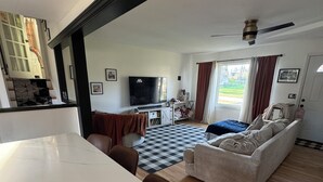 A spacious living area with a large dining table, a sofa, and a television. - 3 Bedroom Ranch with private inground pool just 12 mi. from SPAC and racetrack (Burnt Hills)