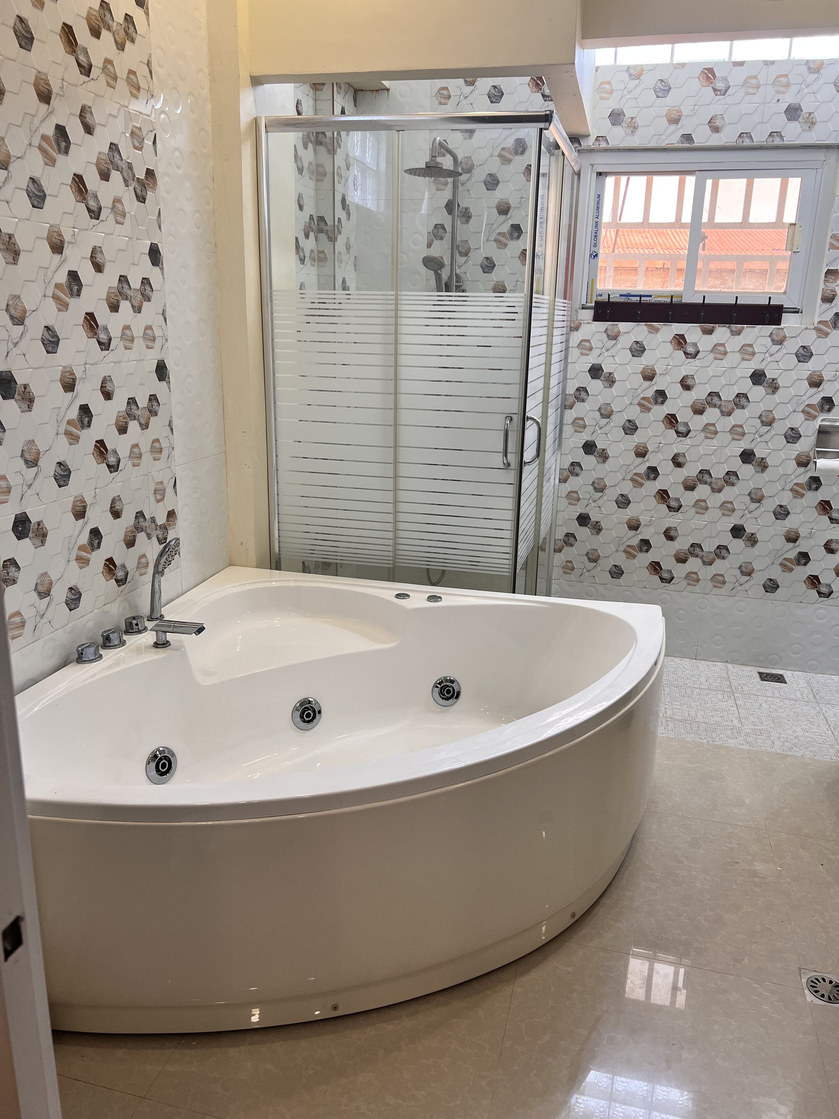 Regadera, tina de hidromasaje, bidet, toallas 