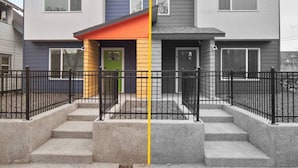 A modern two-story residential building with a grey and blue exterior, a green door, and a red roof. - Your stay will include the entire Unit A to yourself (Spokane)