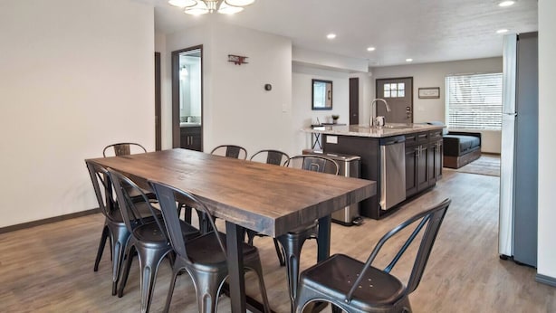 A modern kitchen with a central island, a dining area with a wooden table and metal chairs, and a pendant light fixture. - Your stay will include the entire Unit A to yourself (Spokane)