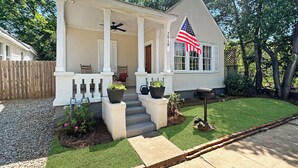 A single-story house with a front porch, a mailbox, and an American flag. - Riverwalk Mill Cottage - Southern Charm Stay (Columbus)