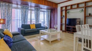 Una sala de estar con sofá, mesa de centro y mueble para televisión.