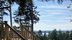 Una escalera de madera que lleva a una terraza con vistas a un lago y un bosque.