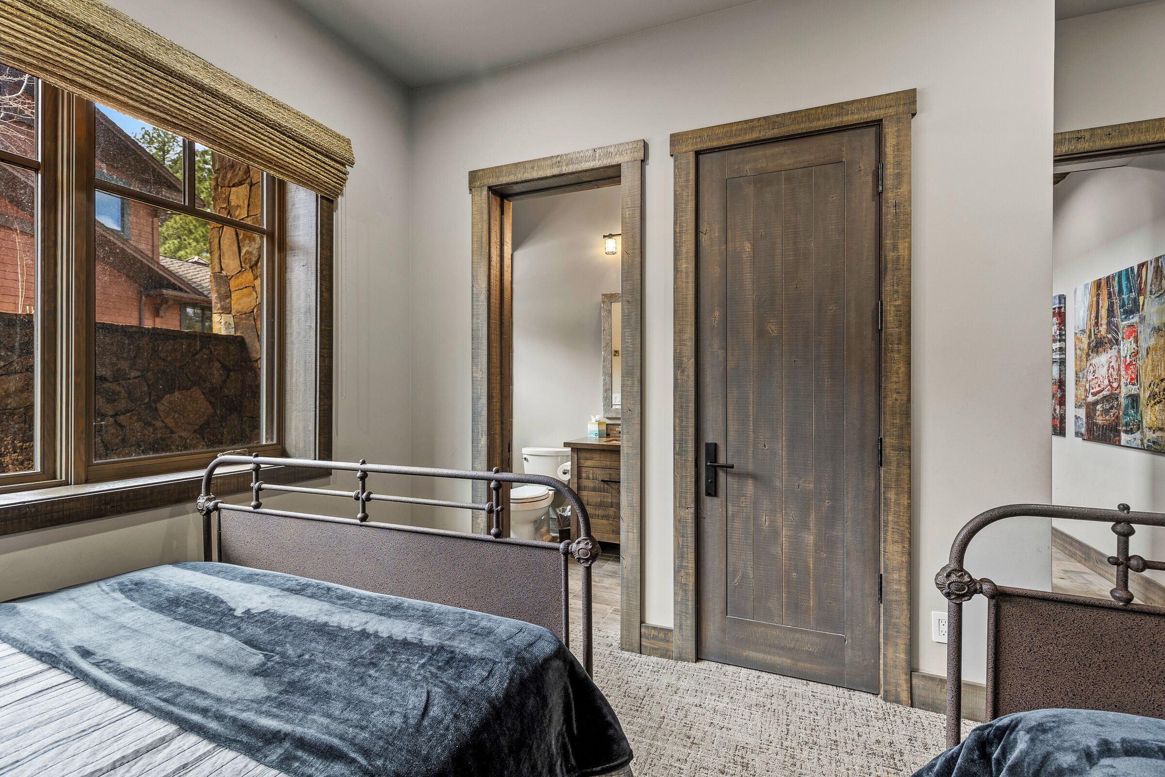 Une chambre à coucher avec un lit, une fenêtre, une porte et un miroir.