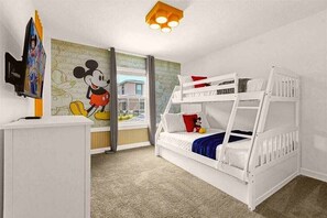A child's bedroom with a bunk bed, a Mickey Mouse mural, and a desk with a computer.
