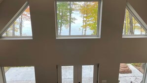 A room with three skylights, a concrete floor, and a view of trees and a body of water. - Sunrise Chalet on Potato Lake - Water Front - Dock - Game Room - Hot Tub (Rusk Township)