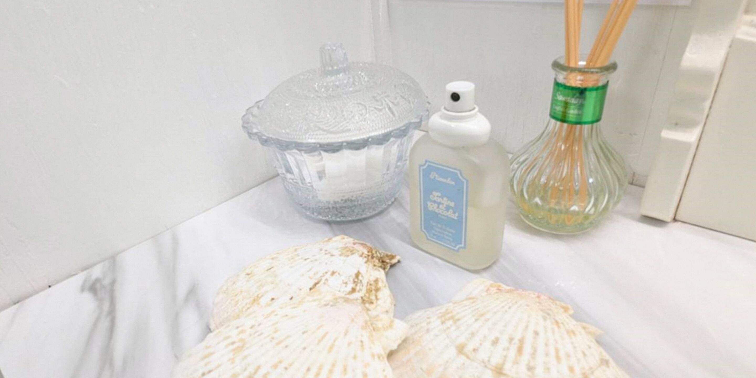A kitchen counter with a glass pie dish, a bottle of liquid soap, and a bottle of reed diffuser.
