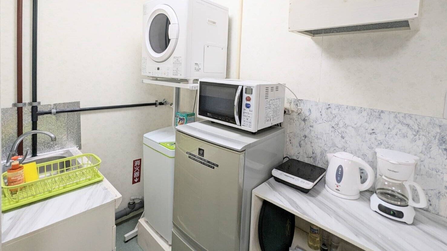 A compact kitchenette with a microwave, coffee maker, and a small refrigerator.