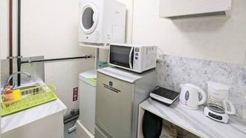 A compact kitchenette with a microwave, coffee maker, and a small refrigerator.