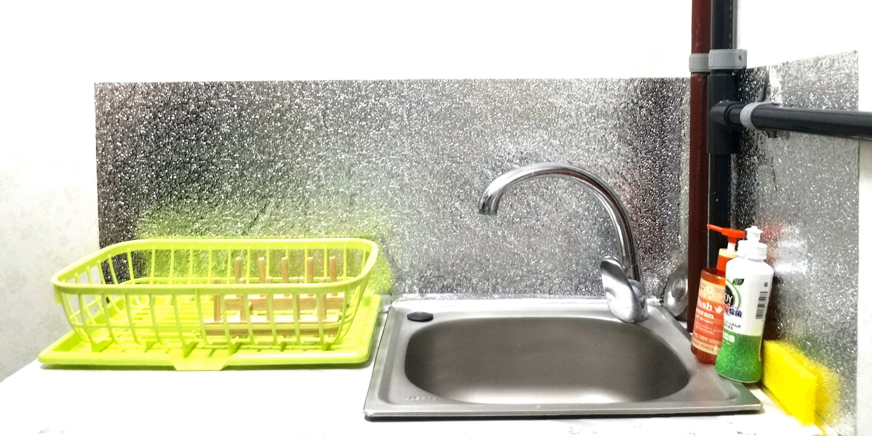 Ein Küchenspüle mit Ablage für Geschirr, einem Wasserhahn und Reinigungsmittel.