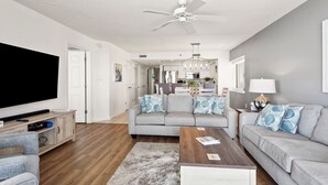 A modern living room with a grey sofa, a wooden coffee table, and a flat-screen TV.