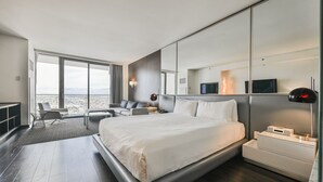 A modern hotel room with a large bed, a seating area with a view, and a flat-screen TV. - SVS: Sunset View Studio | Open Balcony | Pool & Gym | Palms Place (Las Vegas)