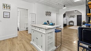 A modern kitchen with white cabinetry, a marble countertop, and a central island. - Charming 2-bedroom bungalow near downtown Atlanta (Atlanta)