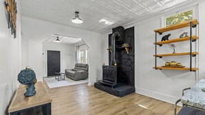 A modern living room with a fireplace, wooden shelves, and a grey sofa. - Charming 2-bedroom bungalow near downtown Atlanta (Atlanta)