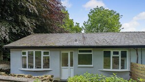 Un petit bâtiment d’un seul étage, doté d’un toit en pente, de fenêtres à cadre blanc et d’une porte.