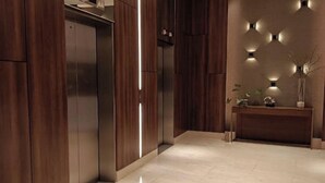 Een moderne lift met houten lambrisering en een strak design.
