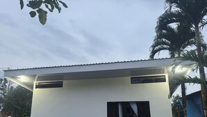 Un edificio pequeño de una sola planta con techo plano y una ventana visible.