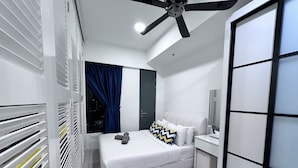A modern bedroom with a bed, a vanity, a ceiling fan, and a window with curtains. - Food Paradise Georgetown 218 Macalister 2BR Family Suite By Smart Space Home (George Town)