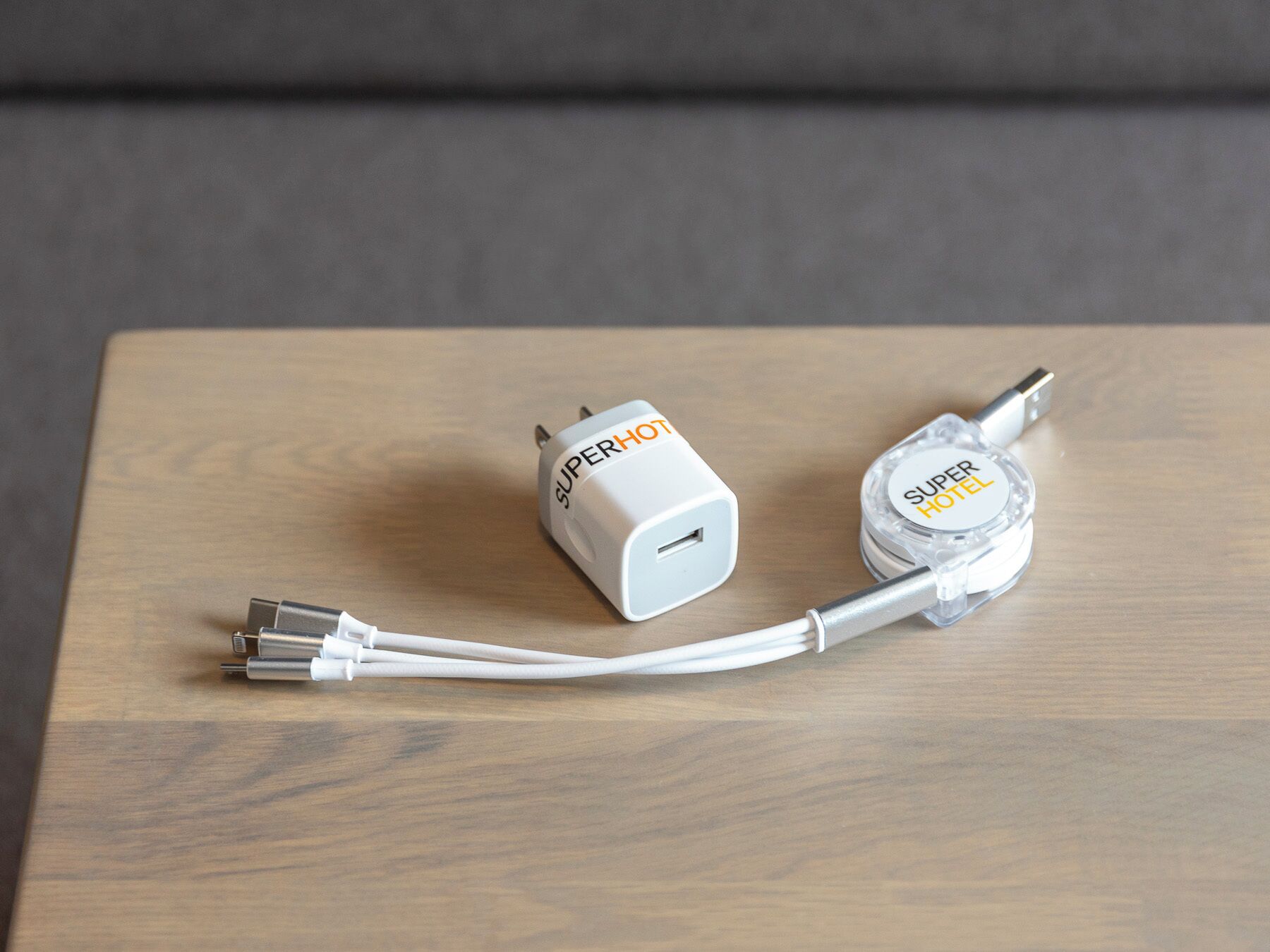 Two white SuperHOT power adapters on a wooden surface.