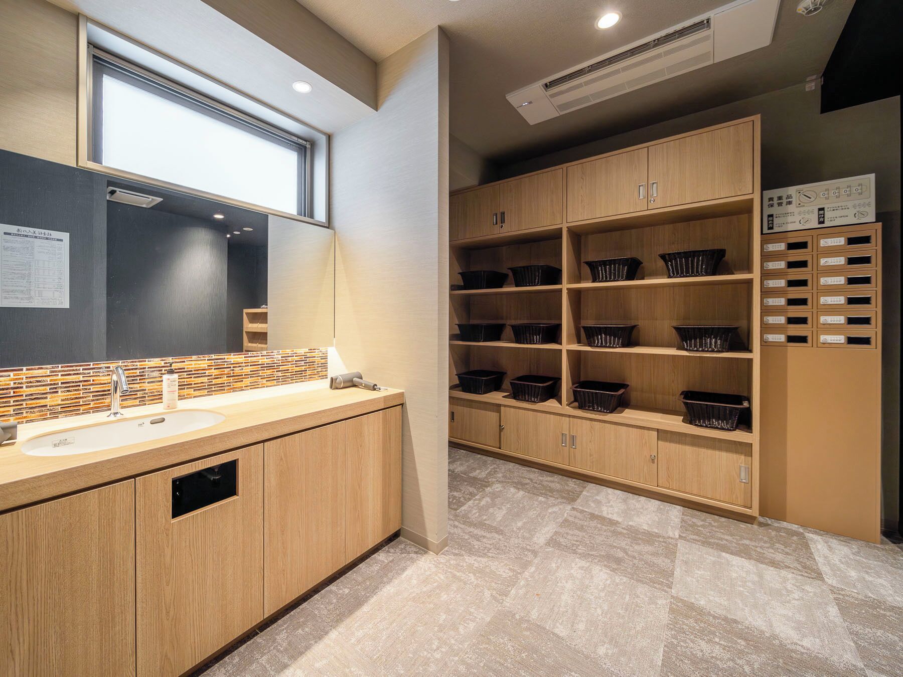 Un baño moderno con un lavamanos grande, espejo y muebles de madera.