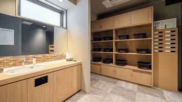 Un baño moderno con un lavamanos grande, espejo y muebles de madera.