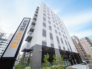 A modern hotel building with a sign reading "SUPERHOTEL".