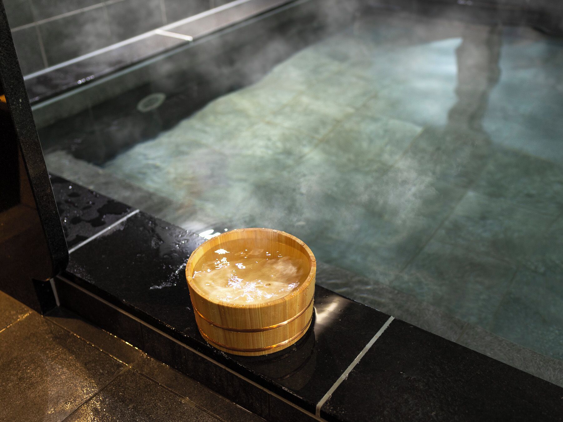 A hot spring bath with a wooden bucket.
