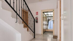 A staircase with black railings leading to an elevator.