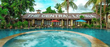 Un hotel con una piscina grande, palmeras y un letrero que dice "The Central Lagoon".