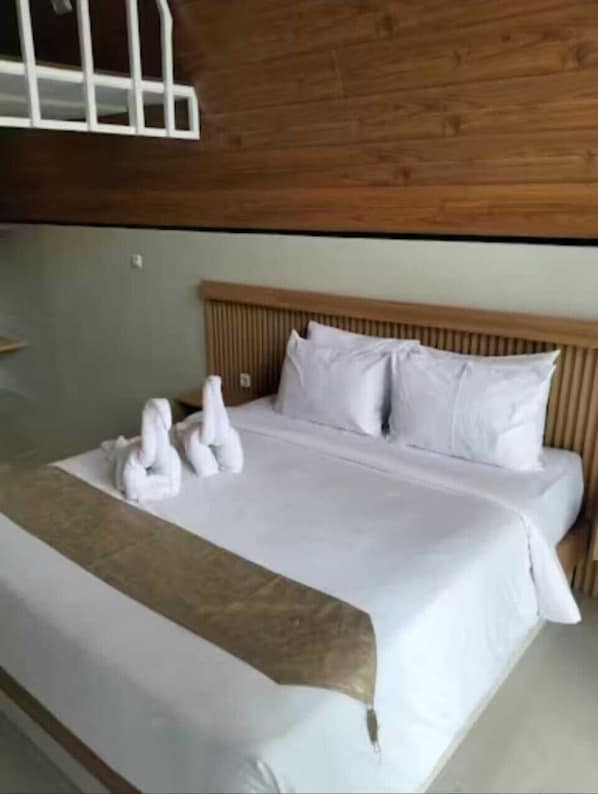 A neatly made bed with white linens, a wooden headboard, and a brown throw blanket. - The central lovina hotel & restaurant (Buleleng)