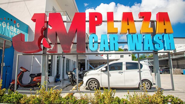 Eine Autowaschanlage mit einem gut sichtbaren Schild mit der Aufschrift "JM PLAZA CAR WASH".