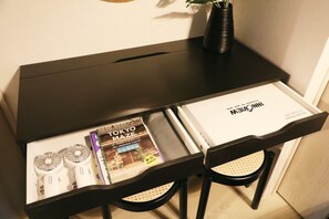 A desk with a book titled "Tokyo Maze" and a white folder with "NNN" branding. - Stellar Nishikoujiya 201  (Tokyo)