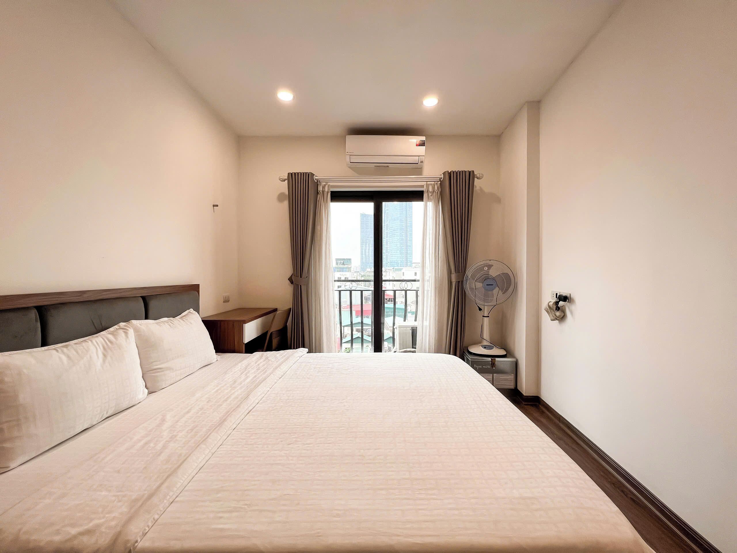 Hotelkamer met een groot bed, een bureau en uitzicht op de stad.