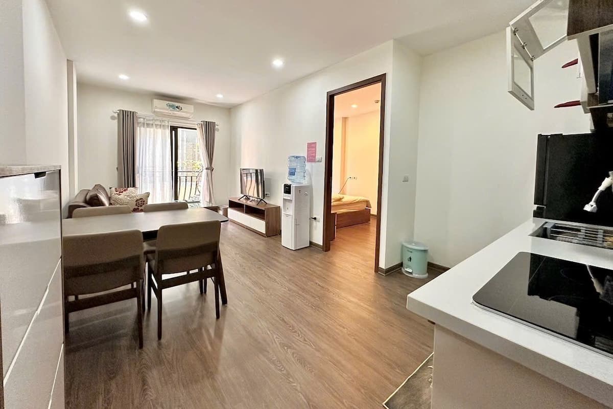A modern kitchen with a dining area, a water dispenser, and a TV.