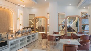 Comedor moderno de hotel con bufé, asientos y vista al interior.