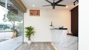 A reception area with a marble counter, a ceiling fan, and a potted plant. - Anta Hotel  (Johor Bahru)