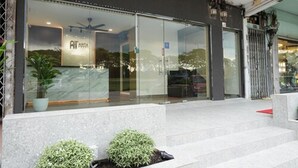 A modern hotel entrance with a glass facade, a reception desk, and a staircase leading to the entrance. - Anta Hotel  (Johor Bahru)