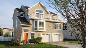 A two-story house with a front porch, a garage, and a balcony. - Henry's Hideaway-Cape May- 2.5 blocks to beach- 5 BR- Elevator (Cape May)