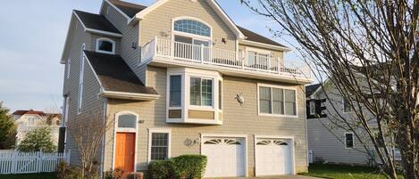 A two-story house with a front porch, a garage, and a balcony.