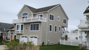 A two-story house with a balcony, multiple windows, and a garage. - Henry's Hideaway-Cape May- 2.5 blocks to beach- 5 BR- Elevator (Cape May)