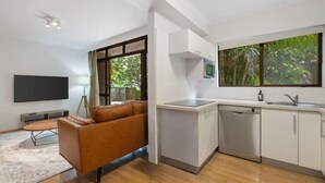 Eine moderne Küche mit Geschirrspüler, eingebautem Backofen und einem Fenster mit Blick auf Grünflächen.
