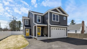 A two-story house with a garage, a front door, and a small front yard. - Cool New Dover Home (Dover)