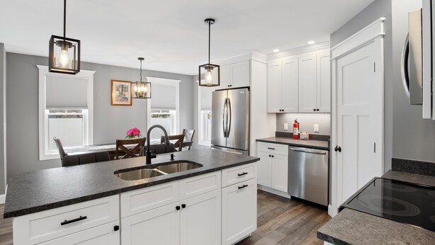 A modern kitchen with white cabinets, a stainless steel refrigerator, and a granite countertop. - Cool New Dover Home (Dover)