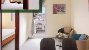 Habitación de un dormitorio con cama, una mesita, sofá y balcón con vistas.