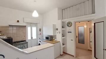 Fridge, coffee/tea maker, cookware/dishes/utensils, dining tables