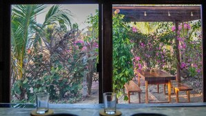 Ein Essbereich mit Blick auf einen Garten durch große Fenster.