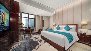 A modern hotel room with a large bed, a desk, and a TV on the left wall. - Maxshure Mezihoo Hotel (Shanghai)