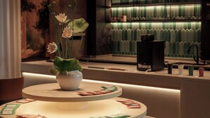 A modern interior with a round table displaying cards and a vase with flowers. - Maxshure Mezihoo Hotel (Shanghai)