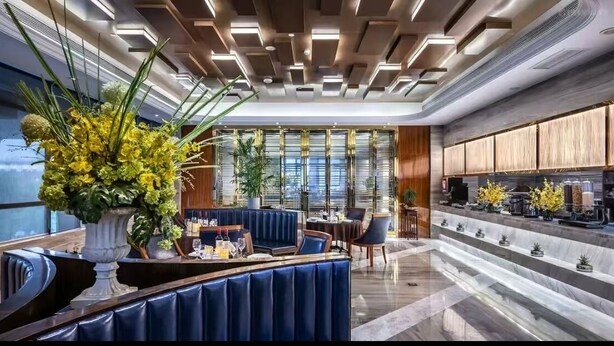 A modern hotel lobby with a curved seating area, a kitchen counter, and large windows. - Maxshure Mezihoo Hotel (Shanghai)