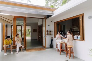 A modern house with an open-plan living area, a dining space, and a large window.